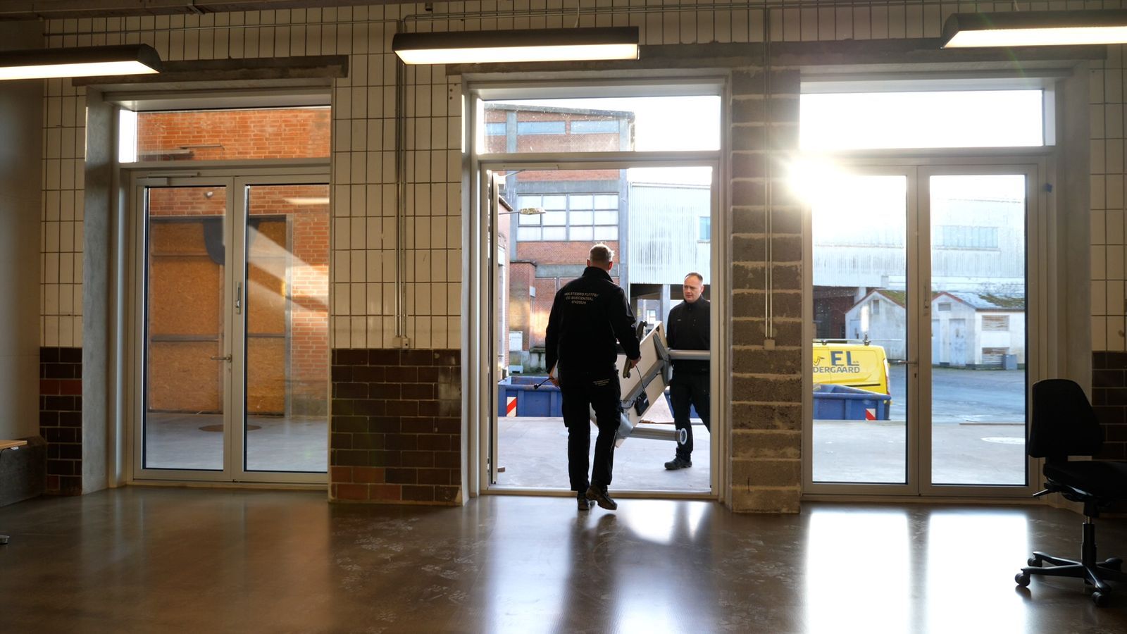 Flyttefolk bærer inventar ud af et erhvervslokale